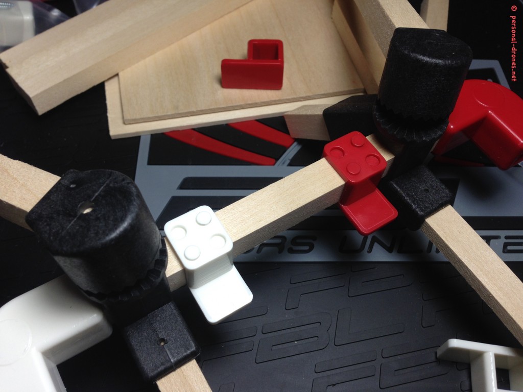 A fist test of Quadlugs components assembly. From left to right, assembled on a frame “side bar”, angle lug, arm lug, plate lug white, plate lug red, arm lug, angle lug red. See how the colors will beautifull help in assessing the quad orientation durintg flight. At this time the plate lugs were still not glued in pairs